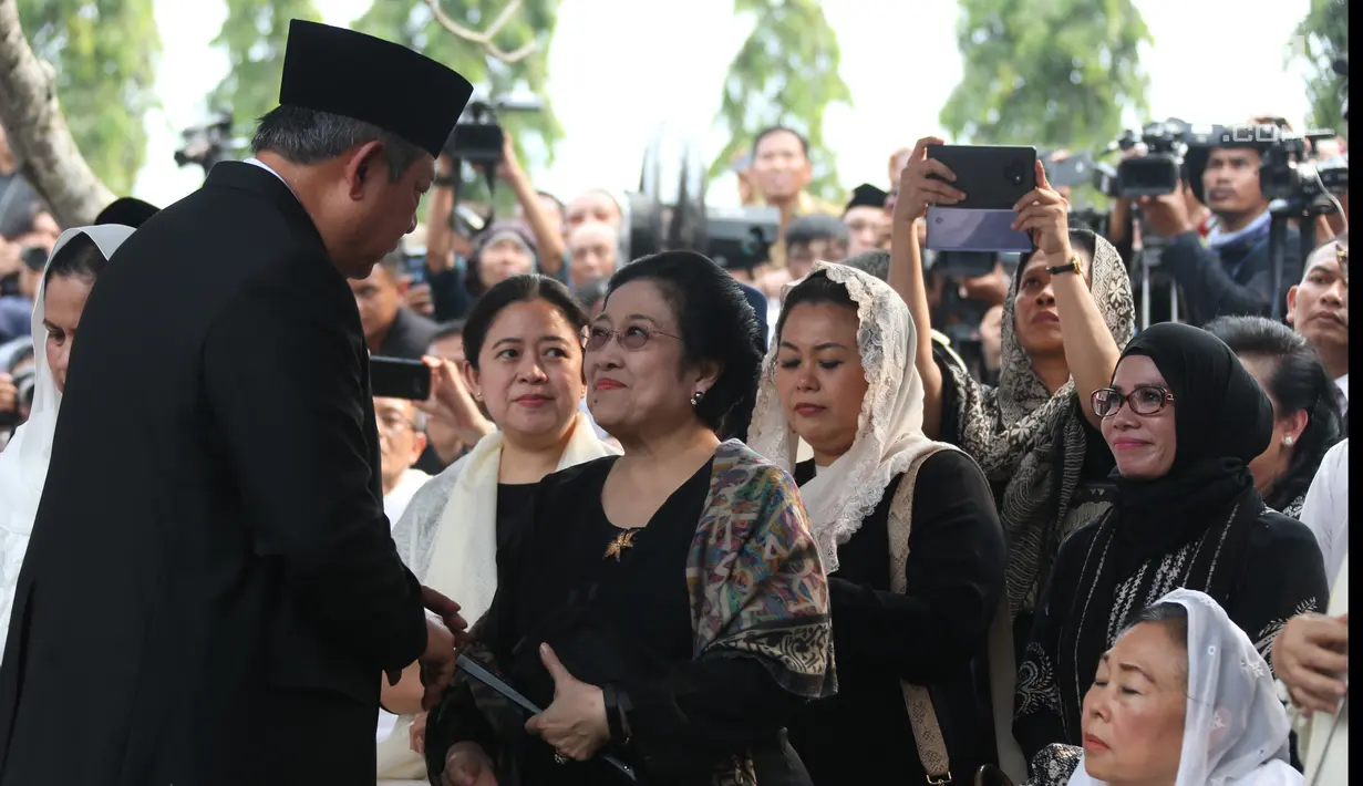 Presiden ke-6 RI Susilo Bambang Yudhoyono bersalaman dengan Presiden ke-5 RI Megawati Soekarnoputri usai prosesi pemakaman Ani Yudhoyono di TMP Kalibata, Jakarta, Minggu (2/6/2019). Megawati duduk bersebelahan dengan Ibu Negara Iriana Joko Widodo dan Sinta Nuriyah Wahid. (Liputan6.com/HO/Rangga)