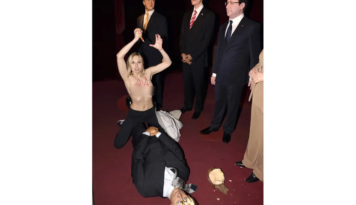 Seorang aktivis Femen menyerang patung lilin Presiden Rusia Vladimir Putin di Museum Grevin, Paris, Kamis (5/6/14). (AFP PHOTO/Eric Feferberg)