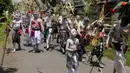 Para pemuda dengan cat tubuh berwarna-warni berkeliling kampung saat ritual Grebeg di Desa Tegallalang, Bali, Rabu (30/1). Tradisi ritual berkeliling kampung dengan riasan tubuh warna-warni itu dipercaya sebagai penangkal Roh jahat. (AP/Firdia Lisnawati)