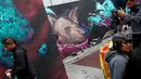 Pengunjung menikmati karya para seniman grafiti yang warnanya berdominan violet di Mexico City, Meksiko, Minggu (9/10). Seni jalanan ini biasanya memang dibuat di tembok-tembok jalan kota. (REUTERS/Carlos JASSO)