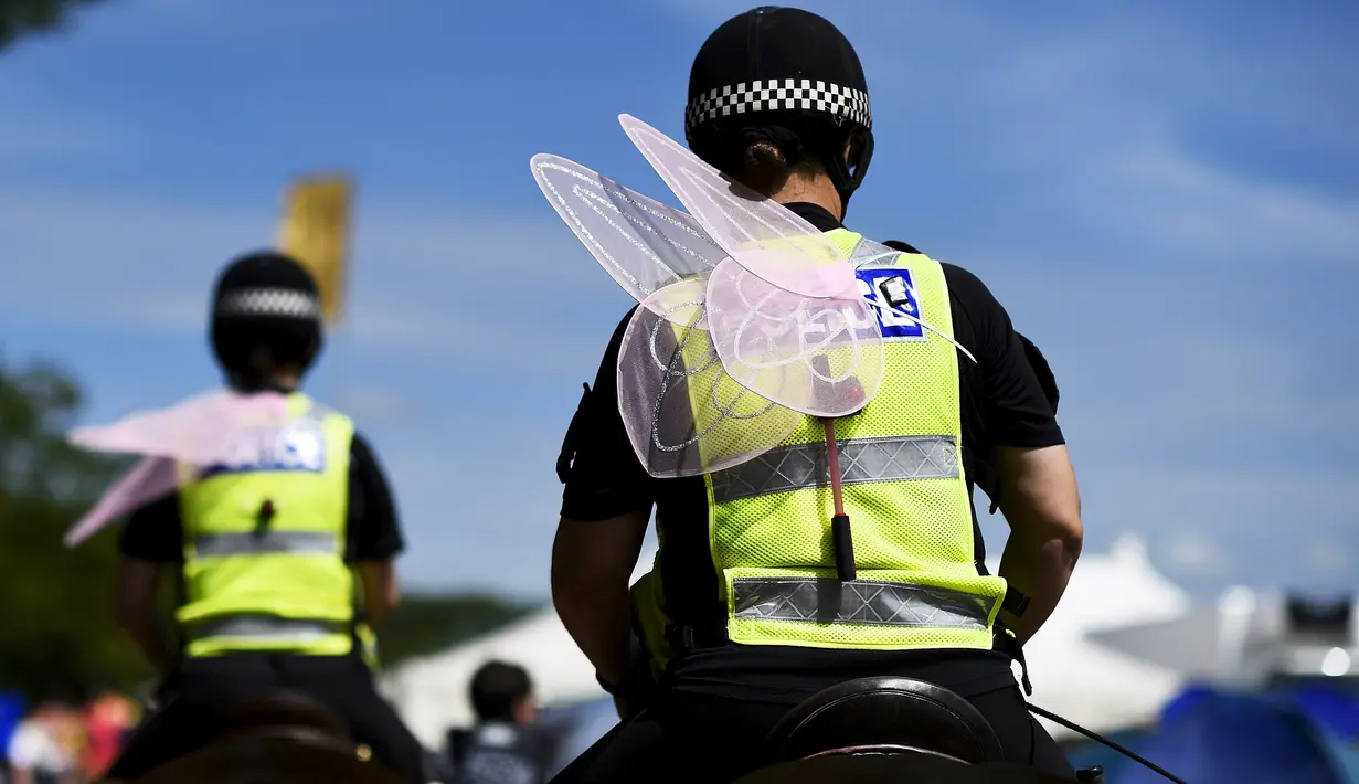 Sejumlah polisi wanita berkuda dengan menggunakan sayap peri melakukan patroli di lokasi Festival Glastonbury, Worthy Farm, Somerset, Inggris, 25 Juni 2015.  (REUTERS/Dylan Martinez) 