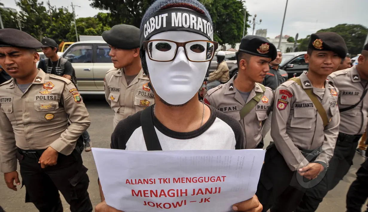 Massa menggunakan topeng saat menggelar aksi unjuk rasa di depan Istana Merdeka, Jakarta, Selasa (7/4/2015). Mereka menagih janji Presiden Jokowi mencabut moratorium terkait larangan pengiriman TKI ke Timur Tengah. (Liputan6.com/Faizal Fanani)