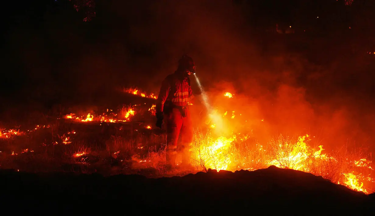 Petugas pemadam kebakaran menggunakan pembakaran terkontrol untuk menghentikan kebakaran hutan yang terus menyebar di dekat Cebreros, provinsi Ávila, Spanyol, Selasa, 28 Juli 2026. (AP Photo/Manu Fernandez)