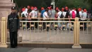 Seorang petugas eamanan berjaga-jaga ketika para wisatawan berjalan di sepanjang jalan di sebelah Lapangan Tiananmen di Beijing (4/6/2019). Pemerintah China meningkatkan keamanan di sekitar Lapangan Tiananmen di pusat Beijing jelang peringatan tragedi Tiananmen 1989. (AP Photo/Mark Schiefelbein)