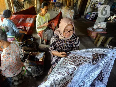 Para perajin menyelesaikan pembuatan batik tulis di Tie Poek Batik, Trenggalek, Jawa Timur, Sabtu (2/9/2023). Batik tulis corak Trenggalek didominasi bunga cengkeh. (merdeka.com/Arie Basuki)