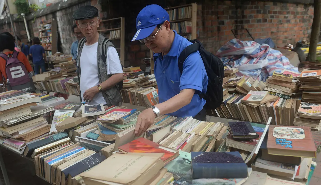 Warga mencari buku yang di jual selama pameran buku bekas di Hanoi, Vietnam  (26/10).( AFP Photo/Hoang Dinh Nam)