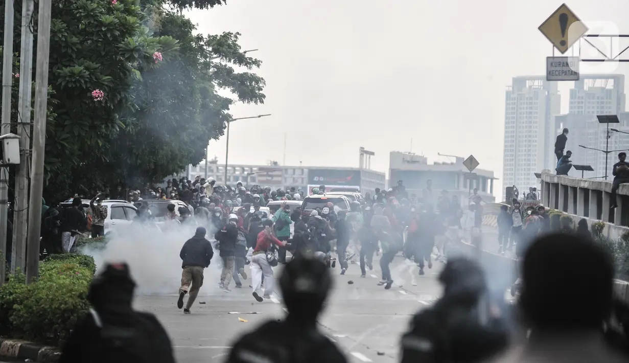 Petugas kepolisian menembakkan gas air mata saat berupaya membubarkan massa yang menggelar aksi di depan Gedung DPR RI, Jakarta, Senin (11/4/2022). Situasi mulai memanas akibat sejumlah pengunjuk rasa melempari petugas dengan berbagai benda. (merdeka.com/Iqbal S Nugroho)