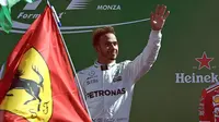 Pembalap Mercedes Lewis Hamilton merayakan kemenangannya di atas podium usai memenangkan balapan F1 GP Italia, di arena Monza, Italia (3/9). (AFP Photo/Miguel Medina)