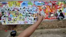 Seniman menunjukkan master mural di selembar kertas dalam acara Project #1/Mural Cikini di Taman Plaza Teater Besar, TIM, Jakarta, Selasa (20/8/2019). Mural tersebut digelar dalam rangka menata estetika ruang publik sebagai sarana interaksi visual masyarakat. (merdeka.com/Iqbal S. Nugroho)