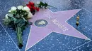 Kepergiannya meninggalkan duka mendalam bagi dunia perfilman dan para penggemar meme. Tampak dalam foto, bunga-bunga diletakkan di bintang Hollywood Walk of Fame Chuck Norris, yang dianugerahkan pada Desember 1989, menyusul berita kematiannya pada Jumat 20 Maret 2026, di Hollywood, California. (Frederic J. Brown/AFP)