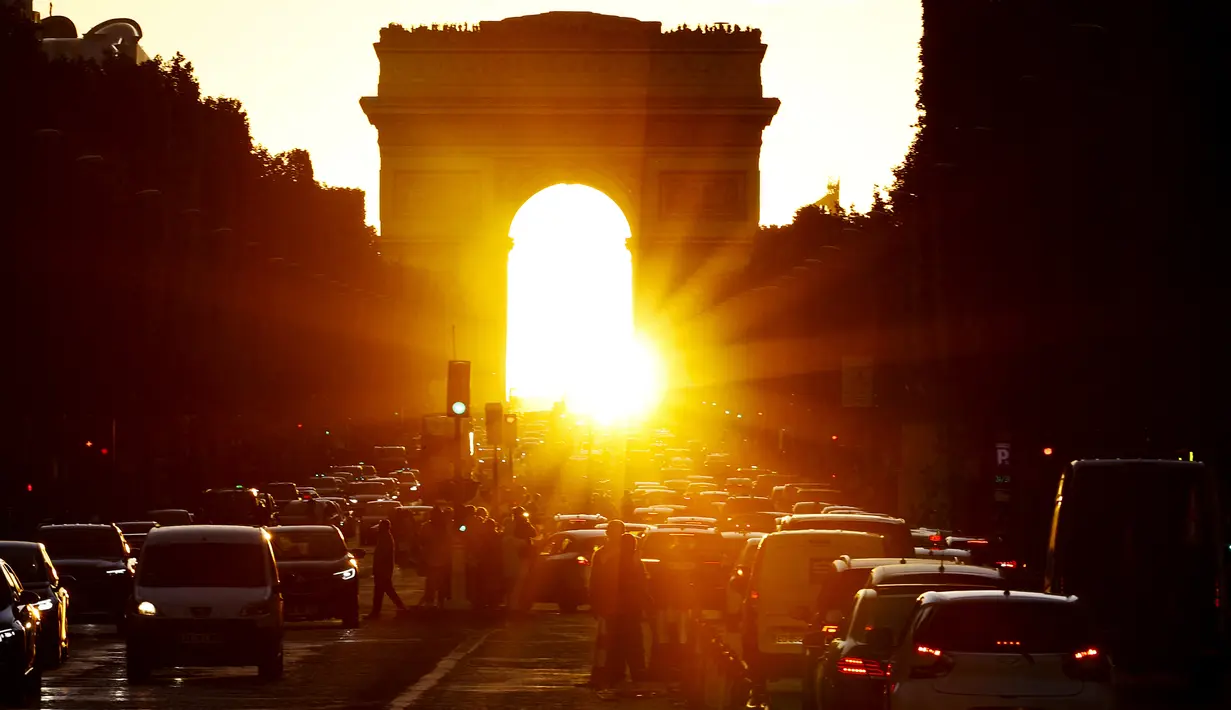 Foto yang diambil pada 2 Agustus 2022 menunjukkan Arc de Triomphe saat matahari terbenam, di Paris. Peristiwa yang dikenal sebagai "Paris Henge" ini terjadi dua kali setahun. (Photo by Stefano RELLANDINI / AFP)