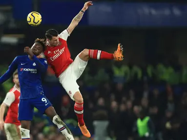 Striker Chelsea, Tammy Abraham berebut bola dengan penyerang Arsenal, Gabriel Martinelli pada lanjutan pertandingan Liga Inggris di Stamford Bridge, Selasa (21/1/2020). Chelsea gagal memetik hasil maksimal usai ditahan Arsenal dengan skor 2-2. (AP Photo/Leila Coker)