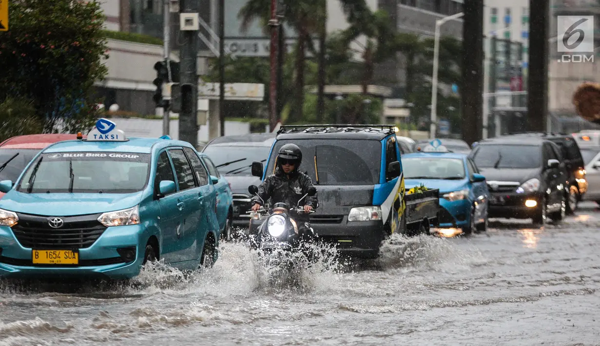 Sejumlah kendaraan melintas menerjang genangan air di kawasan Bunderan HI, Jakarta, Kamis (22/11). Genangan air hujan setinggi 40 cm tersebut disebabkan hujan deras yang melanda Jakarta pada siang hari. (Liputan6.com/Faizal Fanani)