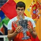 Petenis Spanyol Carlos Alcaraz&nbsp;berselebrasi dengan trofinya&nbsp;usai mengalahkan Casper Ruud dari Norwegia dalam pertandingan final tunggal putra&nbsp;US Open 2022 di USTA Billie Jean King National Tennis Center, New York, pada pada Senin (12/9/2022) pagi WIB. (ANGELA WEISS / AFP)