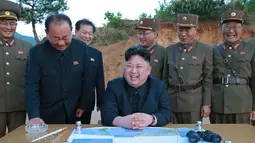 Pemimpin Korea Utara Kim Jong Un saat berada di tempat peluncuran Rudal ballistik jarak jauh Hwasong-12 (Mars-12) di Korea Utara, Selasa (15/5). Rudal Hwansong-12 mampu mencapai ketinggian 2.000km dan menempuh jarak sekitar 700km. (AFP/KCNA)