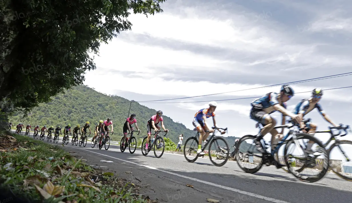 Pebalap Tour de Singkarak 2016 saat melintasi Teluk Bayur pada etape ke-5 Tour de Singkarak dari Pantai Carocok-Painan menuju pantai Gondoriah-Pariaman, Sumatera Barart. (Bola.com/Nicklas Hanoatubun)