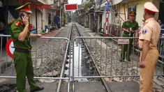 Polisi berjaga dekat barikade rel kereta yang populer sebagai lokasi selfie di Hanoi, Vietnam, Kamis (10/10/2019). Pihak berwenang menutup kafe yang berjajar di pinggir rel kereta tersebut dengan alasan keamanan. (Nhac NGUYEN/AFP)