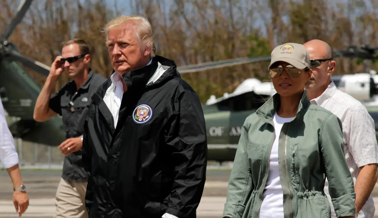 Presiden AS Donald Trump dan ibu negara Melania Trump setibanya di Luis Muniz Air National Guard Base, Puerto Rico, Selasa (3/10). Trump datang untuk melihat langsung kehancuran akibat terjangan badai Maria di Puerto Rico dua pekan lalu. (AP/Evan Vucci)