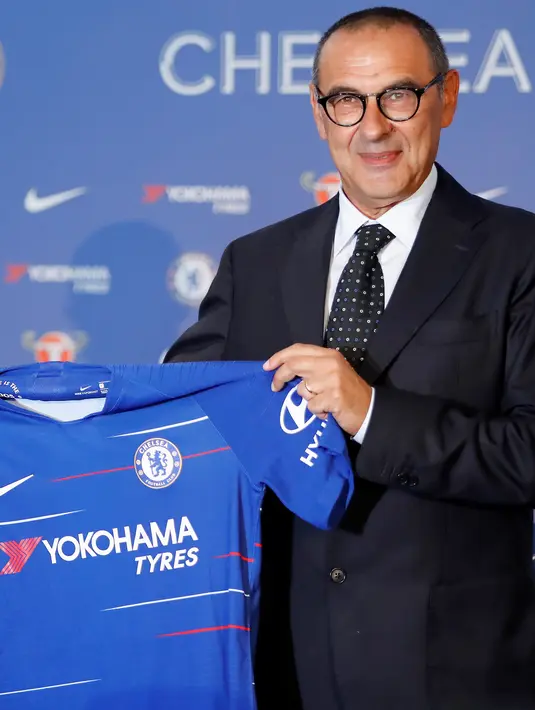 Pelatih baru Chelsea, Maurizio Sarri berpose dengan jersey tim usai konferensi pers di Stamford Bridge di London (18/7). Pria Italia 59 ini resmi menjadi manajer Chelsea selama tiga musim. AP Photo/Kirsty Wigglesworth)