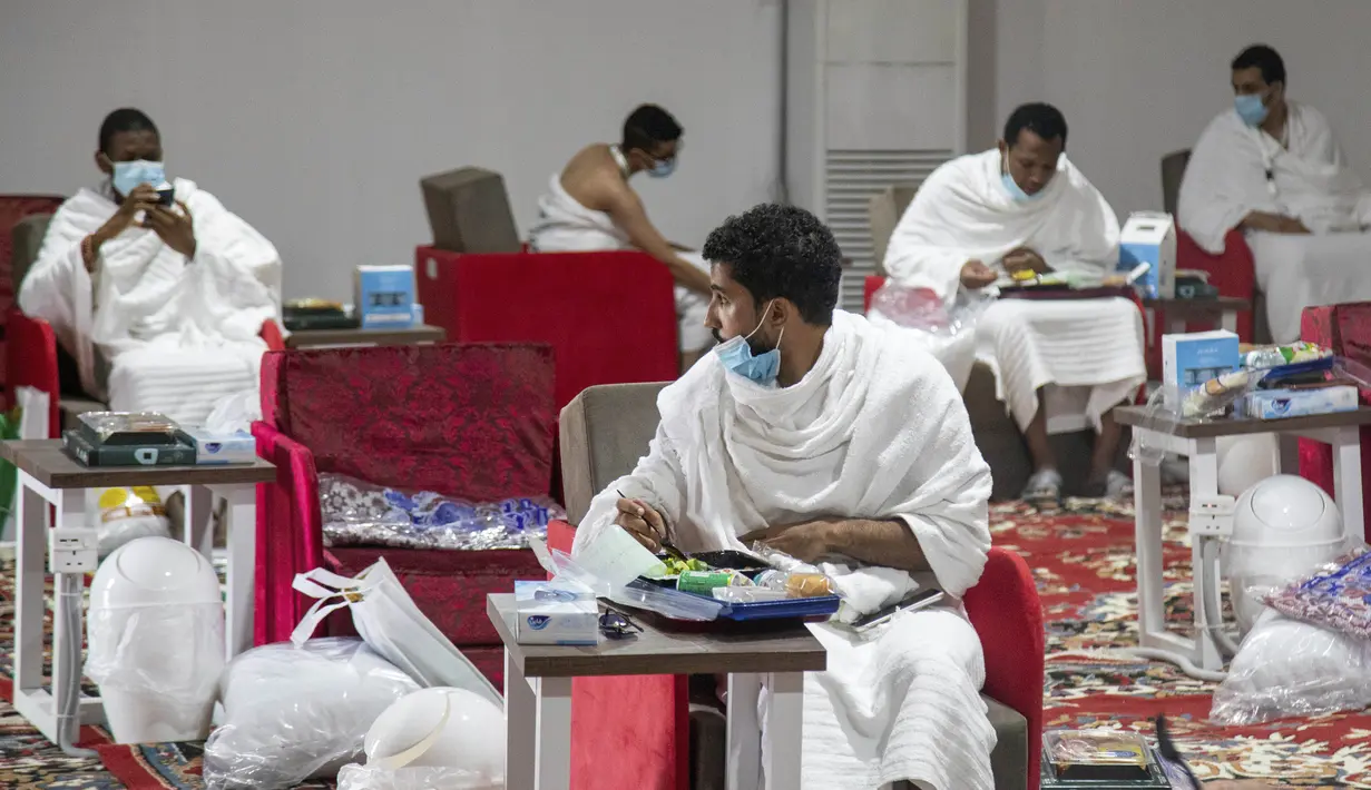 Jemaah makan dalam kamp saat melaksanakan rangkaian ibadah haji di Kota Suci Makkah, Arab Saudi, Kamis (30/7/2020). Hanya sekitar seribu jemaah yang diizinkan untuk melakukan ibadah haji tahun ini karena pandemi COVID-19. (Saudi Ministry of Media via AP)