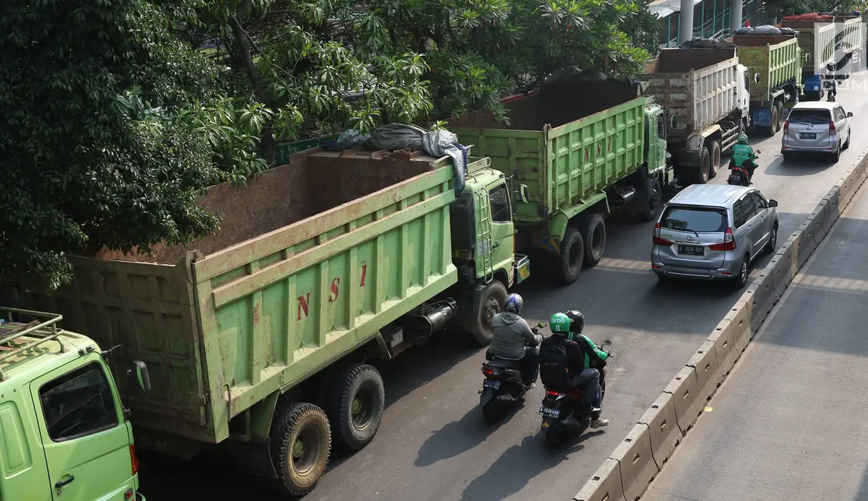 Deretan truk proyek pembangunan Pasar Rumput parkir di tepi Jalan Sultan Agung, Jakarta, Selasa (8/8). Akibat truk proyek parkir hingga menutup sebagian jalur, kawasan tersebut menjadi macet. (Liputan6.com/Immanuel Antonius)