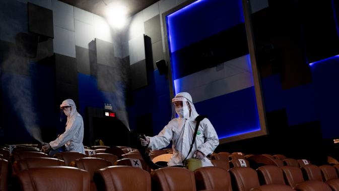 Karyawan menyemprotkan disinfektan sebagai tindakan pencegahan terhadap Covid-19 di bioskop Paragon Cineplex di Bangkok, Thailand, Senin (1/6/2020). (AP Photo/Sakchai Lalit)