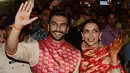 Pasangan pengantin baru, Ranveer Singh dan Deepika Padukone menyapa penggemar yang menyambut mereka di bandara internasional Mumbai, Minggu (18/11). Pasangan bintang Bollywood India itu baru saja kembali dari acara pernikahan mereka di Italia. (AFP)