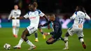 Pemain Paris Saint-Germain (PSG) Kylian Mbappe (tengah) berduel memperebutkan bola dengan pemain Strasbourg Ismael Doukoure (kiri) dan Jean-Ricner Bellegarde pada pertandingan sepak bola Liga Prancis di Parc des Princes, Paris, Prancis, 28 Desember 2022. PSG mengalahkan Strasbourg dengan skor 2-1. (AP Photo/Thibault Camus)