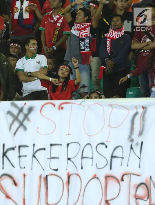 Spanduk keprihatinan terbentang di hadapan suporter yang menyaksikan laga Indonesia U-19 melawan China U-19 pada PSSI 88th U-19 International Tournament di Stadion Pakansari, Cibinong, Selasa (25/9). . (Liputan6.com/Helmi Fithriansyah)