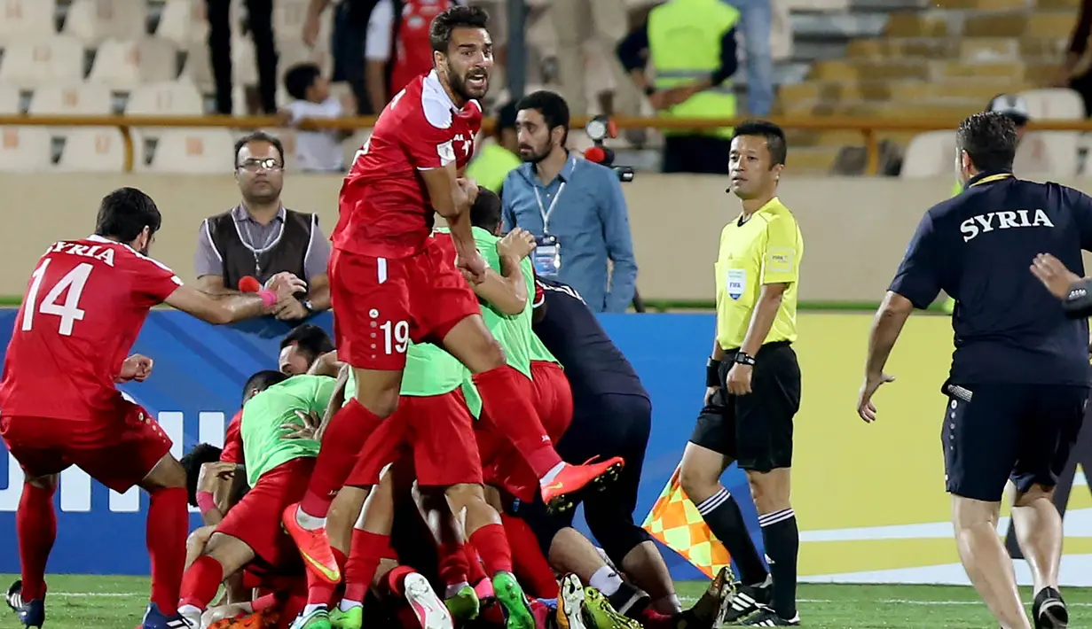 Para pemain Suriah berpesta usai menahan imbang Iran 2-2 pada laga kualifikasi Piala Dunia 2018 di Stadion Azadi, Taheran, Selasa (5/9/2017). Finis urutan tiga grup A, Suriah lolos ke babak playoff untuk menantang Australia. (AFP/Atta Kenare)