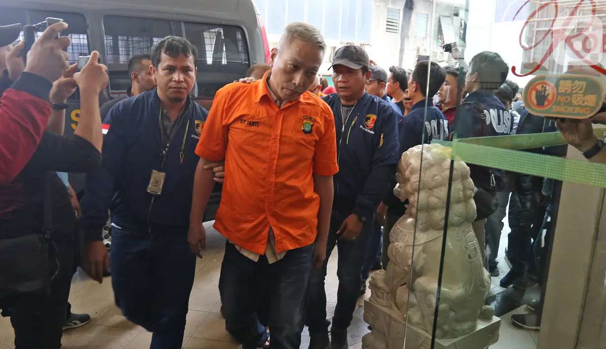 Seorang tersangka dihadirkan saat rilis kasus perjudian di Apartemen Robinson, Jakarta Utara, Selasa (8/10/2019). Polisi juga mengamankan sejumlah barang bukti seperti meja perjudian, uang senilai 200 juta, telepon genggam dan papan dan kartu untuk permainan judi. (Liputan6.com/Herman Zakharia)