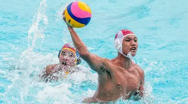 Pemain polo air putra Indonesia Hizkia Bimantoro (kanan) melempar bola ke gawang Kamboja yang dijaga Run Suosdey pada pertandingan polo air beregu putra SEA Games 2023 di Phnom Penh, Kamboja, Jumat (12/5/2023). (AP Photo/Tatan Syuflana)