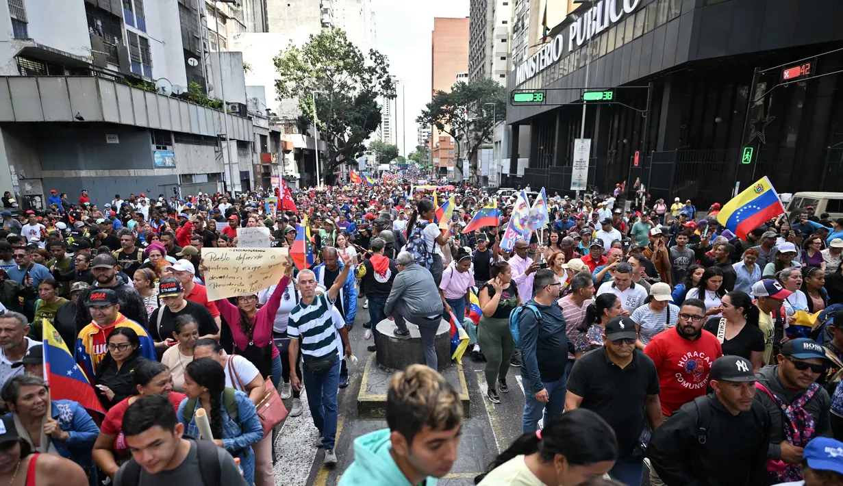 Bahkan, putra Nicolas Maduro yang merupakan anggota Kongres menyerukan pada Minggu 4 Januari 2026 agar warga Venezuela turun ke jalan setelah ayahnya ditangkap oleh pasukan AS dan dipindahkan ke penjara New York. Tampak dalam foto, pendukung mantan Presiden Venezuela, Nicolas Maduro, saat menggelar aksi unjuk rasa di Caracas pada Minggu 4 Januari 2026. (Juan BARRETO/AFP)