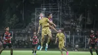 Pemain Barcelona Juvenil A melakukan duel udara dengan pemain Timnas U-17 dalam laga uji coba di Stadion Ngurah Rai Denpasar, Rabu (2/8/2023). (Bola.com/Alit Binawan)