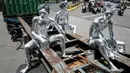 Foto yang diambil pada 7 April 2025 ini menunjukkan manusia silver Keris Munandar (kanan), saudaranya Ari Munandar (kiri), dan tetangganya Riyan Ahmad Fazriyansah menumpang di bagian belakang truk kontainer untuk mencapai persimpangan di Jakarta. (Yasuyoshi CHIBA/AFP)