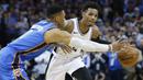Pebasket San Antonio Spurs, Dejounte Murray, berusaha melewati pebasket Oklahoma City Thunder, Russell Westbrook, pada laga NBA di Chesapeake Energy Arena, Minggu (11/3/2018). Thunder menang 104-94 atas Spurs. (AP/Sue Ogrocki)
