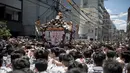 Peserta membawa kuil portabel atau "Mikoshi" pada Festival Sanja Matsuri di luar kuil Sensoji, distrik Asakusa, Tokyo, Minggu (20/5). Sanja Matsuri ini adalah salah satu festival agama Shinto terbesar yang diadakan di Tokyo. (AFP/Behrouz MEHRI)