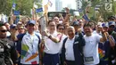 Presiden Direktur PT. Astra International Tbk, Prijono (kedua kiri) menyalakan obor saat kirab Obor Asian Games 2018 di Jalan Jendral Sudirman, Jakarta, Sabtu (18/8). (Liputan6.com/ Fery Pradolo)