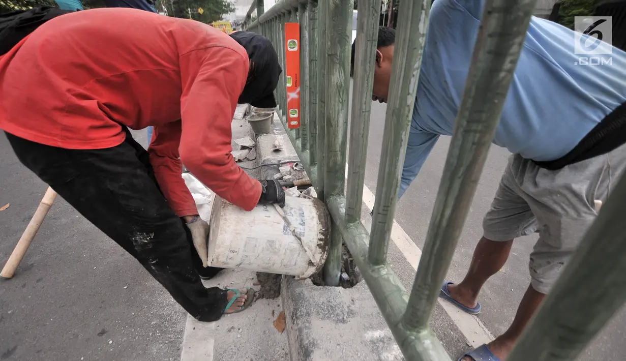 Pekerja dari Dinas Perhubungan DKI Jakarta melakukan pemasangan pagar pembatas jalan di Jalan HOS. Cokroaminoto, Jakarta, Selasa (6/11). Pemasangan pagar pembatas ini mengantisipasi kecelakaan di jalan tersebut. (Merdeka.com/ Iqbal S. Nugroho)
