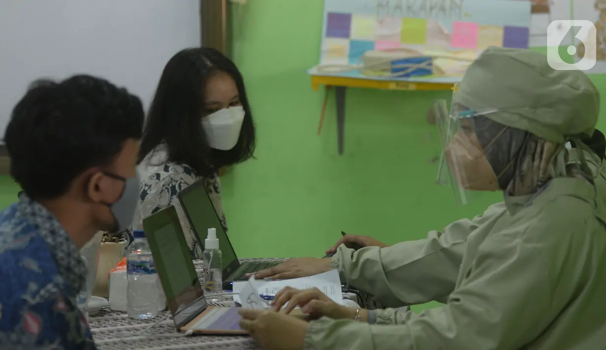 Petugas medis menjelaskan vaksinasi Covid-19 kepada siswa di SMUN 20 Jakarta, Kamis (1/7/2021). Target 1,3 juta anak di Jakarta disuntik vaksin Corona. (merdeka.com/Imam Buhori)