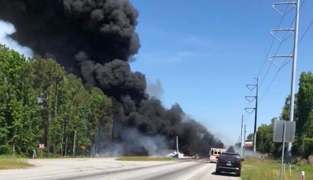 Kepulan asap hitam mengudara setelah sebuah pesawat kargo militer Amerika Serikat jatuh di jalan raya dekat bandara Savannah, Georgia, Rabu (2/5). Sembilan orang dinyatakan tewas dalam insiden jatuhnya pesawat kargo militer C-130 itu (James Lavine via AP)