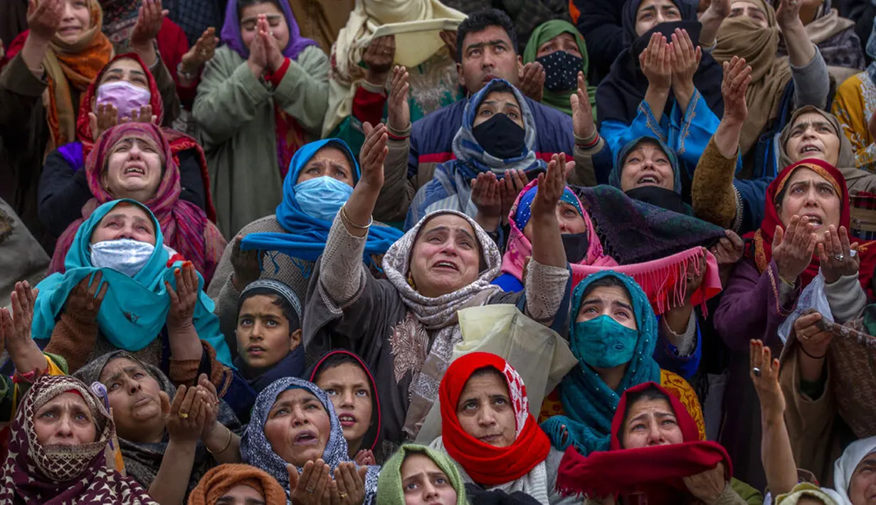 Para wanita muslimah memanjatkan doa saat imam memamerkan peninggalan Nabi Muhammad pada peringatan Isra Miraj di Masjid Hazratbal, Srinagar, Kashmir, India, Jumat (12/3/2021). Ribuan muslim Kashmir berkumpul di Masjid Hazratbal yang menyimpan janggut Nabi Muhammad. (AP Photo/Dar Yasin)