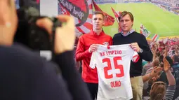 Gelandang baru RB Leipzig asal Spanyol, Dani Olmo bersama direktur olahraga Markus Kroesche berpose dengan jersey klub barunya di Leipzig, Jerman timur (27/1/2020). Dani Olmo bakal bermain di Red Bull Arena selama 4,5 tahun ke depan. (Jan Woitas/dpa/AFP)