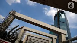 Suasana pembangunan LRT di tikungan Jembatan 66 Kuningan-Dukuh Atas, Jakarta, Senin (6/7/2020). Pembangunan LRT Jabodebek tersebut nantinya akan terkoneksi dengan kawasan terpadu TOD yang menggabungkan transportasi MRT, Kereta Commuter line dan Bus Transjakarta. (merdeka.com/Dwi Narwoko)
