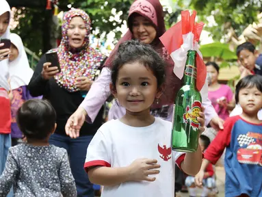 Anak Ayu Ting Ting, Bilqis Khumaira Rozak memegang botol berisi bendera saat mengikuti lomba memindahkan bendera di kawasan Depok, Jawa Barat, Kamis (17/8). Lomba tersebut digelar untuk menyambut HUT ke-72 Kemerdekaan RI. (Liputan6.com/Herman Zakharia)
