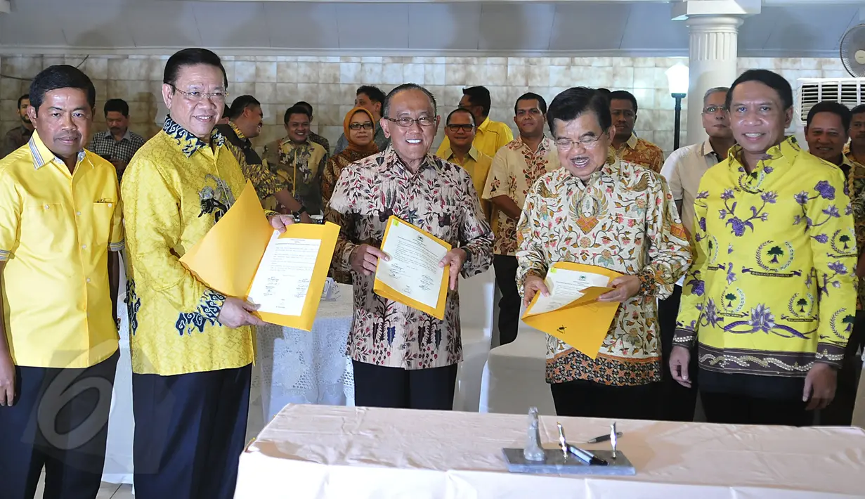 Wapres Jusuf Kalla bersama Ketum Partai Golkar versi munas Bali Aburizal Bakrie dan Ketum Partai Golkar versi munas Ancol Agung Laksono menunjukan berkas kesepakatan islah setelah menandatanganinya di Jakarta, Sabtu (30/5). (Liputan6.com/Johan Tallo)