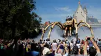 Sejumlah orang melihat robot mekanik laba-laba raksasa bernama Kumo Ni saat berjalan berkeliling Kota Nantes, Prancis, Jumat (8/7). Robot Mekanik laba-laba raksasa ini di buat oleh perusahaan La Machine. (REUTERS/Stephane Mahe)