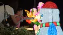 Seorang anak perempuan menyentuh dekorasi cahaya manusia salju di "Festival Cahaya" yang diadakan di Jurong Lake Gardens, Singapura, pada 20 Desember 2020. "Festival Cahaya" berlangsung dari 18 Desember 2020 hingga 3 Januari 2021. (Xinhua/Then Chih Wey)