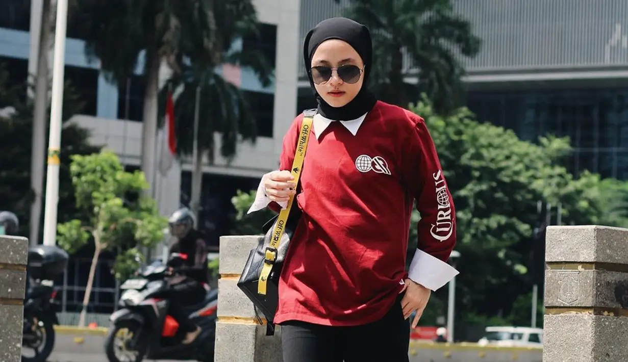 Menggunakan baju sweater berkerah, wanita berhijab ini semakin menawan dengan hijab pashmina yang diikat ke belakang. Gayangnya semakin trendi dengan kacamata hitam dan slingbag yg eye catching.(Liputan6.com/IG/@nissa_sabyan)