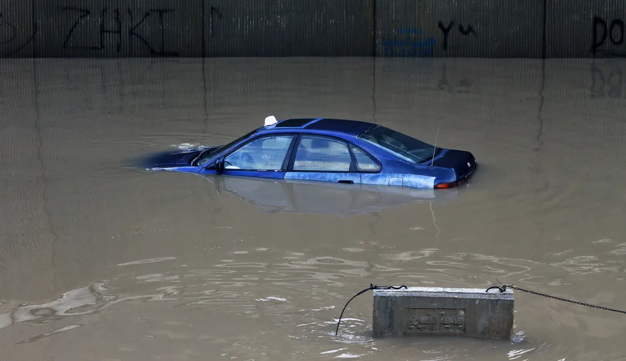 Sebuah mobil terendam banjir di terowongan di pinggiran selatan Beirut Ouzai, Lebanon (9/12/2019). Hujan deras membuat sejumlah rumah dan kendaraan di Lebanon terendam banjir dan melumpuhkan daerah-daerah dari ibukota Beirut, Lebanon. (AP Photo/Bilal Hussein)